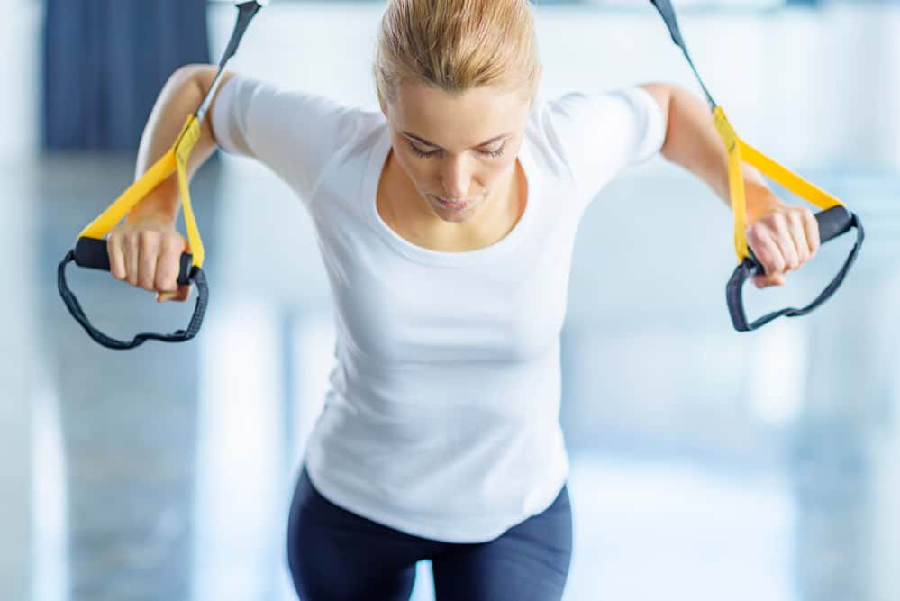 woman using a TRX suspension trainer