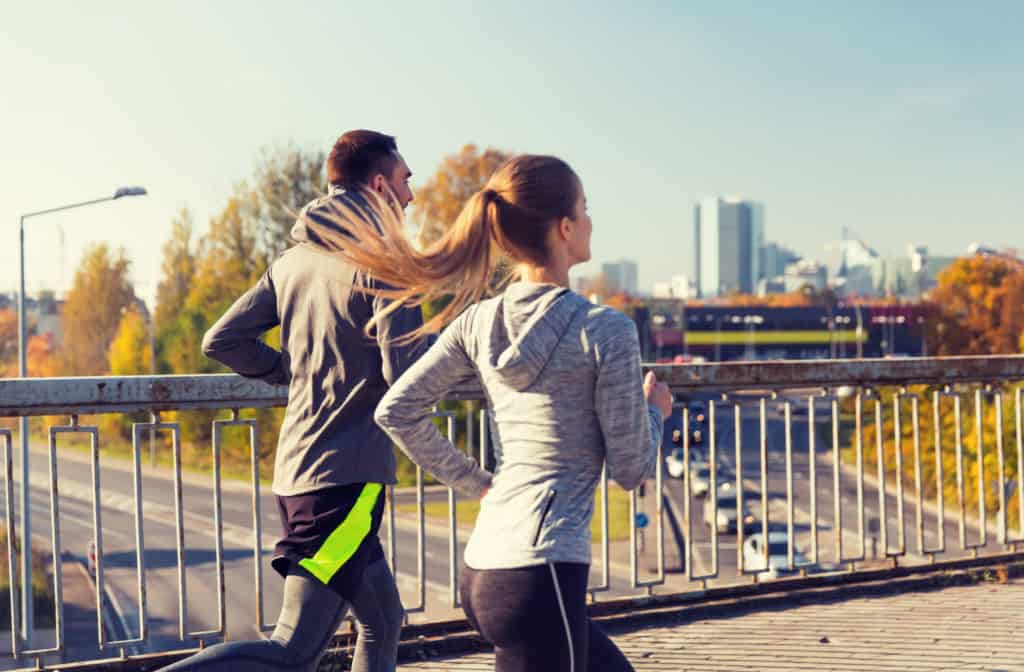 Fitness Sport People And Jogging Concept Happy Couple Running Outdoors Happy Couple Running Outdoors