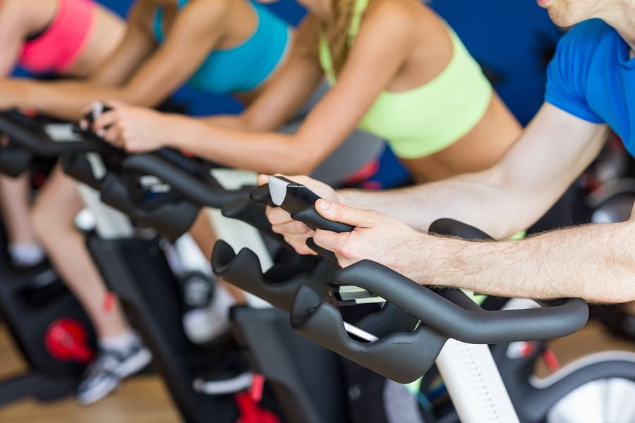 people riding a spin bike in a spin class