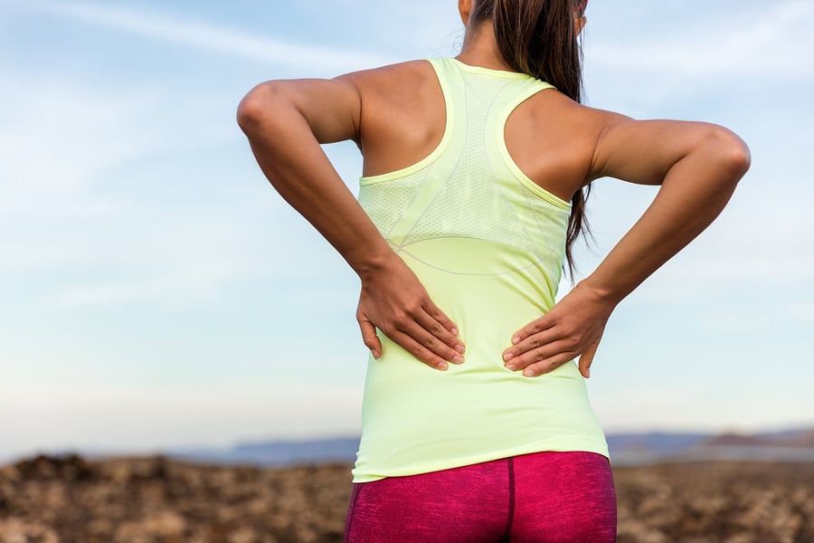 woman runner holding lower back in pain staying active with lower back pain