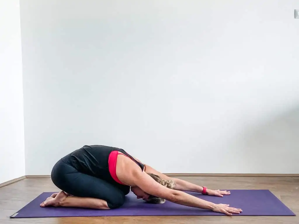 woman on a yoga mat demonstrating child's pose