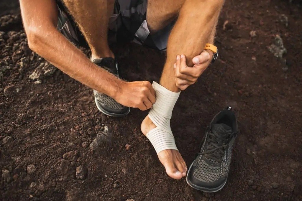 athletic man wrapping his foot due to plantar fasciitis
