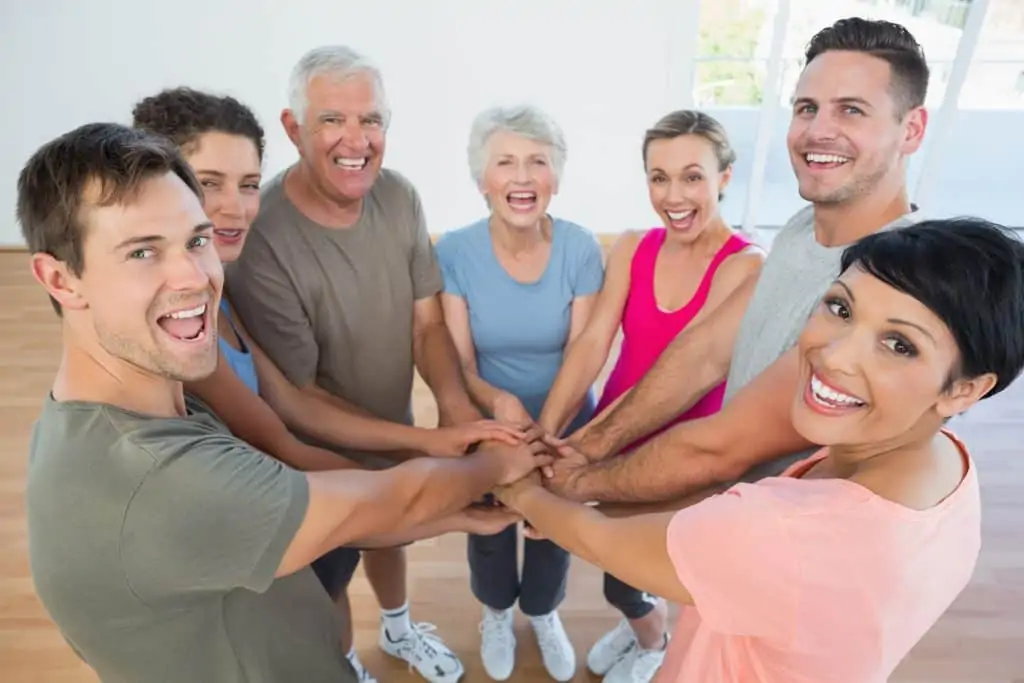 group of people at a fitness class with hands in how to be more active