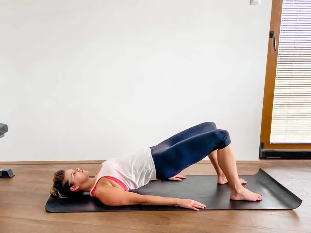 woman demonstrating a supine bridge for glute strengthening
