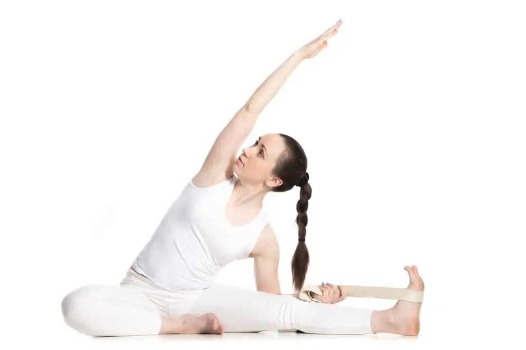 woman using a yoga strap to modify a yoga pose