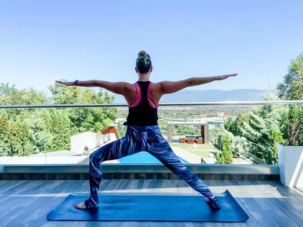 woman doing yoga outdoors in warrior 2