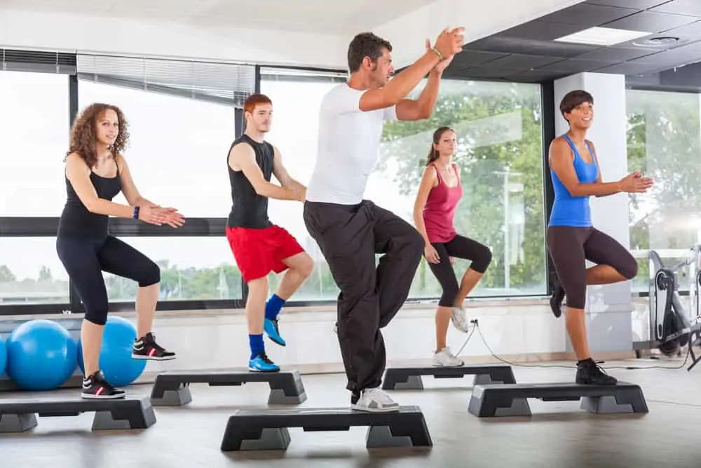 a group fitness class doing step aerobics, a decorative image in an article about step aerobics for beginners