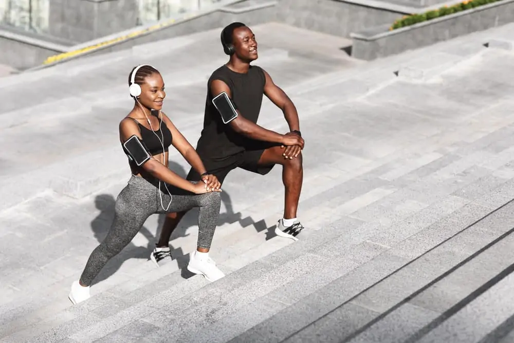 african american man and woman stretching outside during a workout