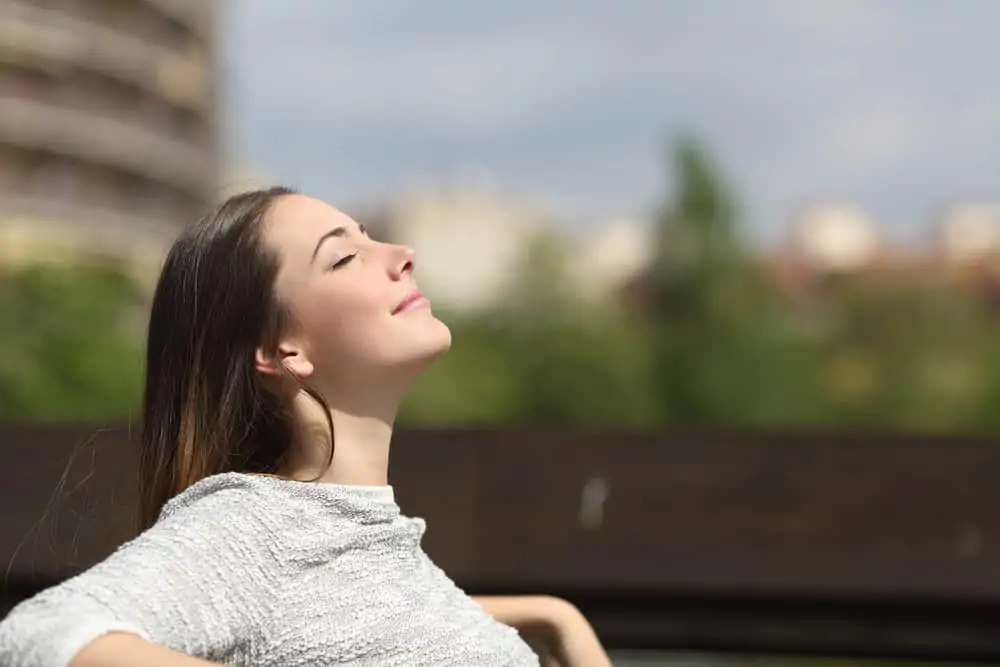woman sitting outside breathing deeply