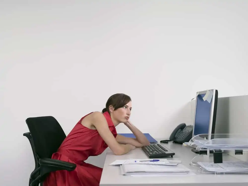 woman slouching at her desk - how to stop slouching when sitting