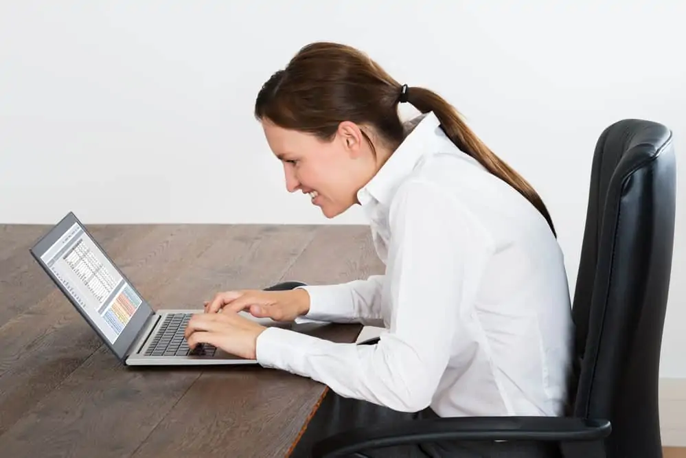 woman slouching over a computer screen