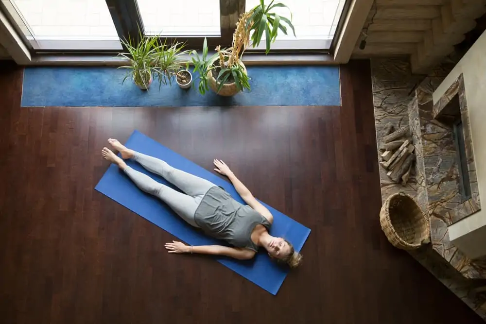 woman lying on a yoga mat relaxing