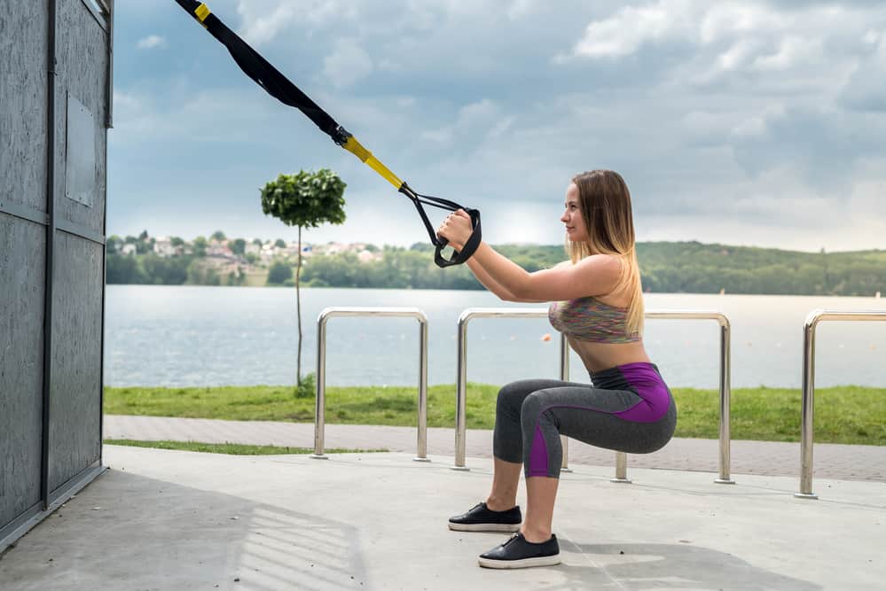 woman performing a trx workout - decorative for an article about what is a trx workout?