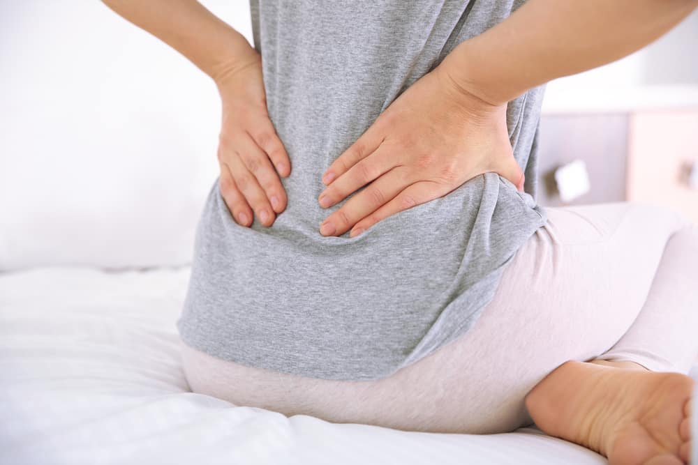 woman holding painful lower back