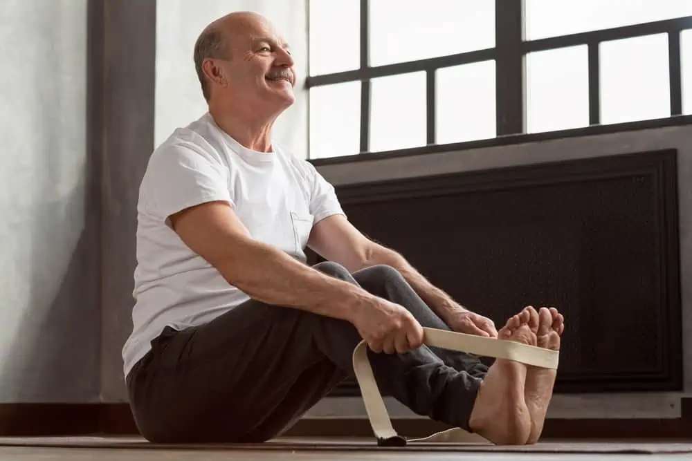 man doing yoga with a strap