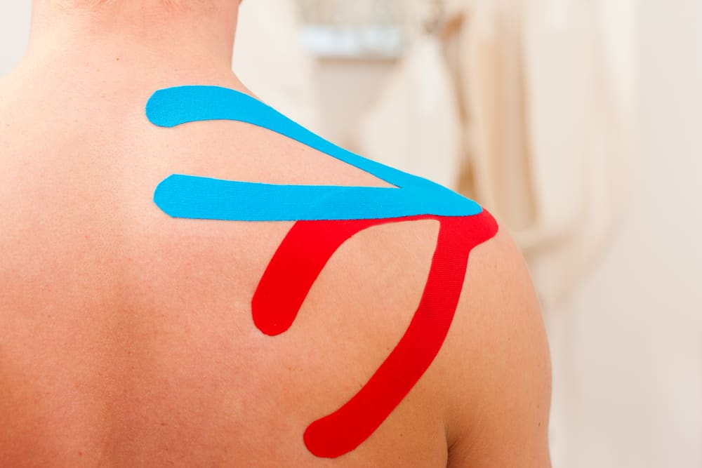 person with kinesiology tape on their shoulder