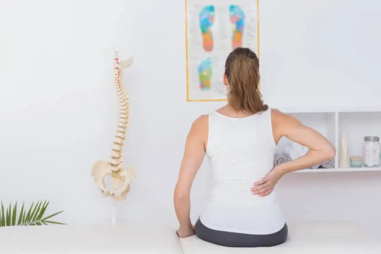 13 stretches for low back pain - woman in a physical therapy office with back pain
